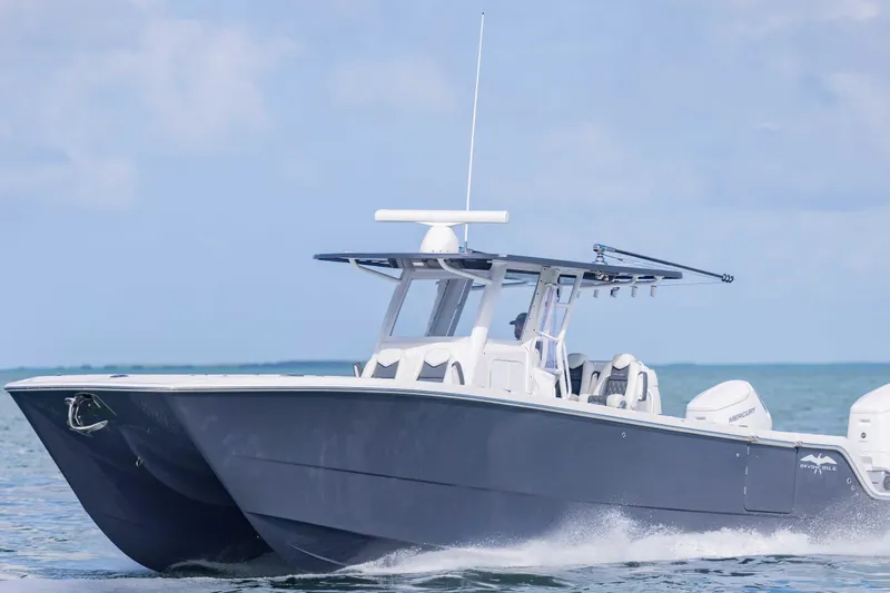  Yacht Photos Pics 2023 Invincible 35 Catamaran cruising on open water under clear skies.