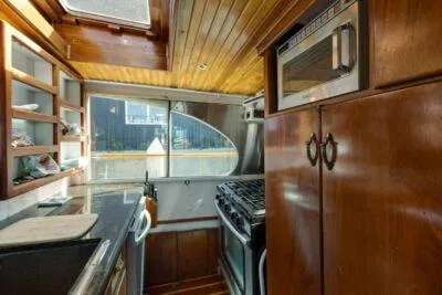 Flamingo Yacht Photos Pics 1950 Monk Pilothouse kitchen with wood cabinetry and modern appliances.