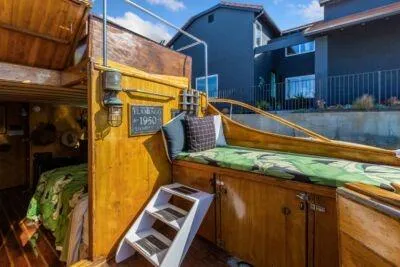 Flamingo Yacht Photos Pics 1950 Monk Pilothouse boat interior with wooden finish and cozy bedding.