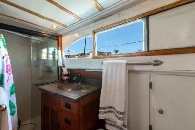 Flamingo Yacht Photos Pics 1950 Monk Pilothouse bathroom with wooden vanity, towel rack, and window view.