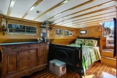 Flamingo Yacht Photos Pics 1950 Monk Pilothouse interior with wooden decor and cozy bed.