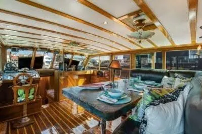 Flamingo Yacht Photos Pics 1950 Monk Pilothouse interior with wooden accents and dining setup.