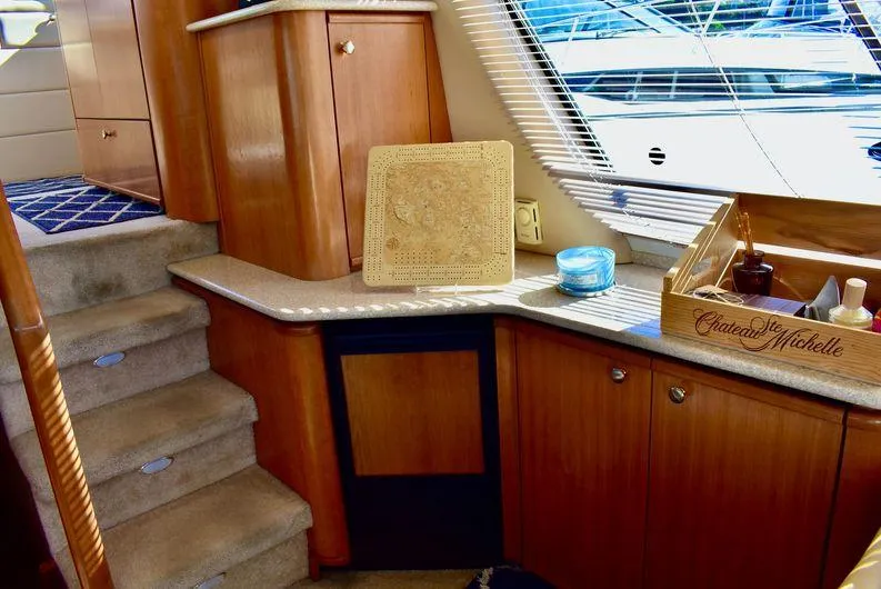 "magic" Yacht Photos Pics Interior of 2004 Meridian 490 Pilothouse with wooden cabinetry and carpeted stairs.