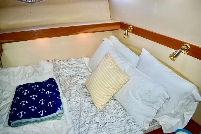 "magic" Yacht Photos Pics Cozy bedroom in 2004 Meridian 490 Pilothouse with nautical-themed blanket and pillows.