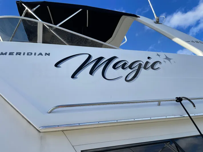"magic" Yacht Photos Pics 2004 Meridian 490 Pilothouse yacht with "Magic" name, sleek design, and blue sky background.
