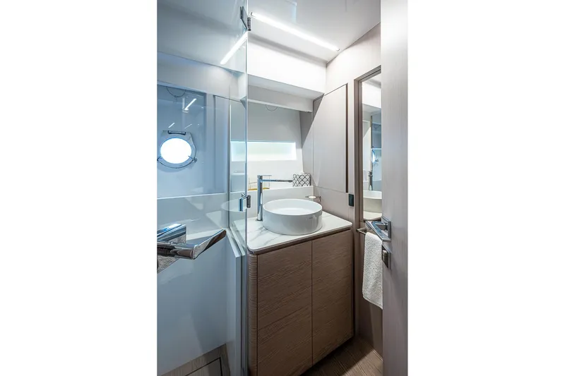  Yacht Photos Pics Luxurious bathroom interior of 2021 Ferretti Yachts 500 with modern fixtures and porthole window.
