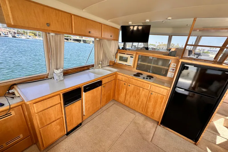Barkruiser Yacht Photos Pics Navigator 4800 yacht kitchen interior, 1998 model, featuring wood cabinetry and modern appliances.