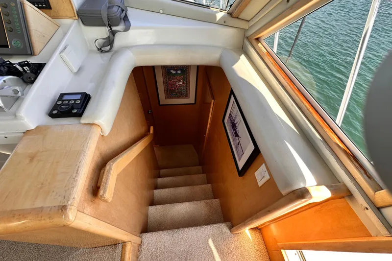 Barkruiser Yacht Photos Pics Staircase inside 1998 Navigator 4800 yacht, with wood paneling and framed artwork.