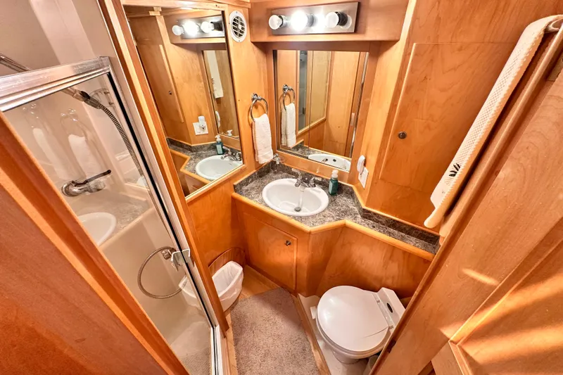 Barkruiser Yacht Photos Pics Compact 1998 Navigator 4800 bathroom with shower, sink, and toilet in wooden interior.