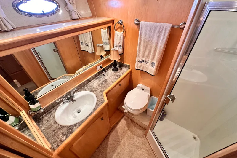 Barkruiser Yacht Photos Pics Luxurious 1998 Navigator 4800 yacht bathroom with sink, toilet, and shower.