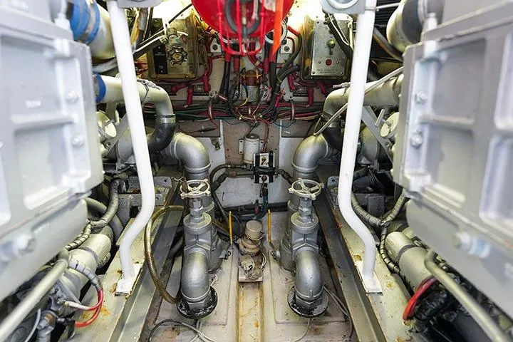 Impulse Yacht Photos Pics Engine room of a 1987 Viking Palm Beach boat, showcasing mechanical components and piping.