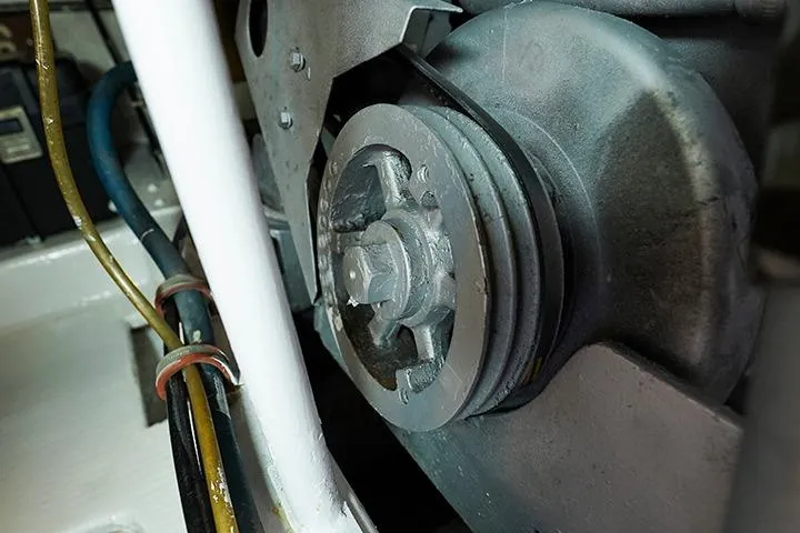 Impulse Yacht Photos Pics Close-up of a 1987 Viking Palm Beach engine component with visible belts and wires.