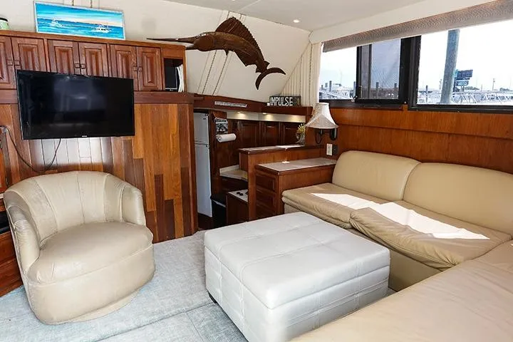 Impulse Yacht Photos Pics Interior of 1987 Viking Palm Beach yacht with cozy seating and wooden accents.