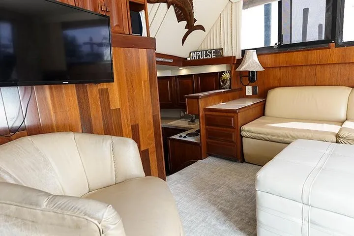 Impulse Yacht Photos Pics Interior of a 1987 Viking Palm Beach yacht with wood paneling and beige seating.