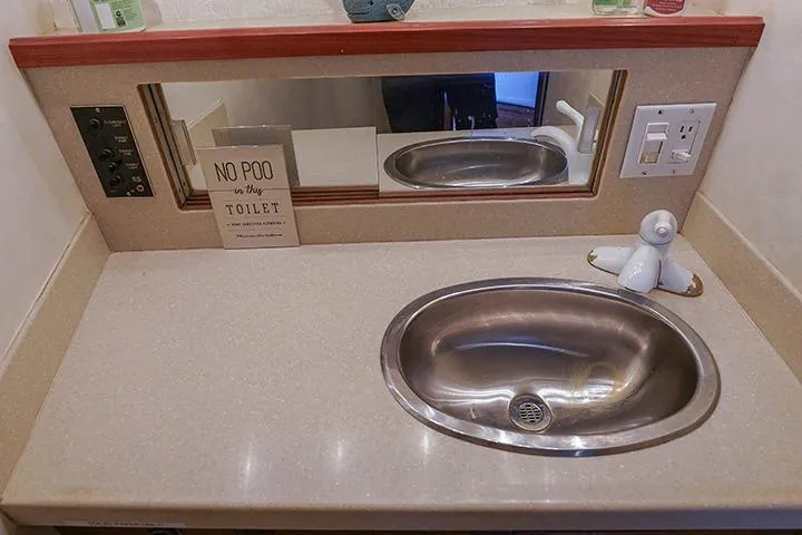 Impulse Yacht Photos Pics 1987 Viking Palm Beach bathroom sink with mirror and humorous sign.