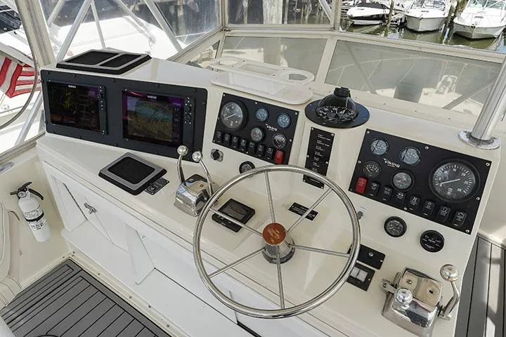 Impulse Yacht Photos Pics 1987 Viking Palm Beach boat helm with navigation instruments and steering wheel.