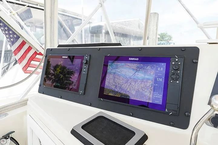 Impulse Yacht Photos Pics 1987 Viking Palm Beach boat dashboard with Simrad navigation screens and American flag.