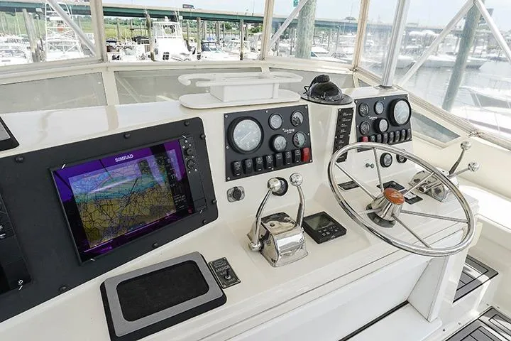 Impulse Yacht Photos Pics Cockpit of 1987 Viking Palm Beach yacht with navigation equipment and steering wheel.