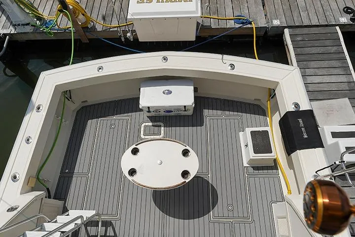 Impulse Yacht Photos Pics 1987 Viking Palm Beach boat deck with fishing gear and cooler at dock.