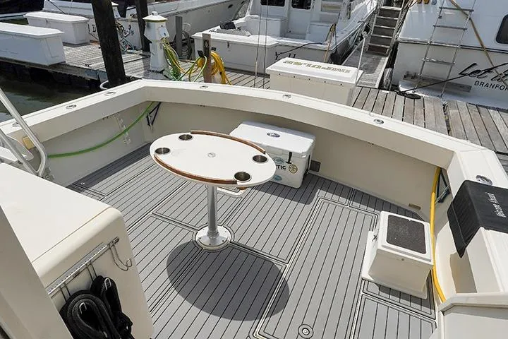 Impulse Yacht Photos Pics 1987 Viking Palm Beach boat deck with table and seating at marina.