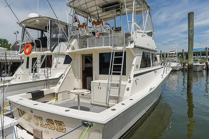 Impulse Yacht Photos Pics 1987 Viking Palm Beach yacht docked at marina, featuring spacious deck and upper helm.
