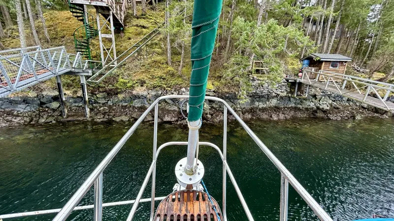  Yacht Photos Pics Bow of Custom Seawing-Atkins 2002 boat near rocky shoreline and forested area.