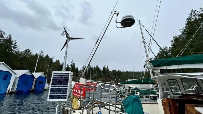  Yacht Photos Pics Sailboat with wind turbine and solar panel docked near blue boathouses, Custom Seawing-Atkins 2002.