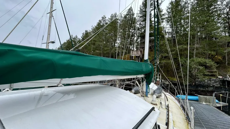 Yacht Photos Pics Sailboat docked near forest, Custom Seawing-Atkins 2002, with green sail cover.