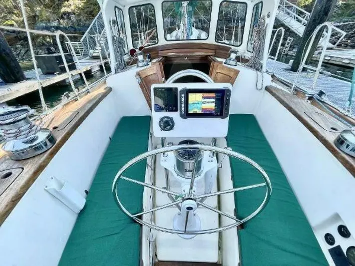  Yacht Photos Pics Cockpit of 2002 Custom Seawing-Atkins sailboat with green cushions and navigation equipment.