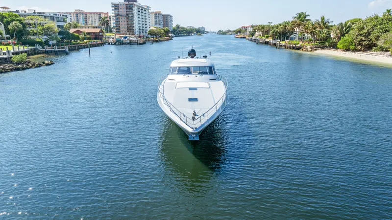 Alchemy Yacht Photos Pics 2003 Baia PANTHER 80 yacht cruising on a scenic waterway with lush surroundings.
