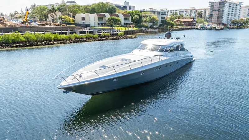 Alchemy Yacht Photos Pics 2003 Baia Panther 80 yacht cruising on a calm waterway near a residential area.