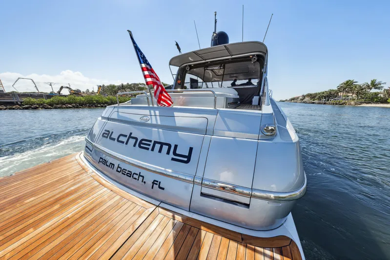 Alchemy Yacht Photos Pics Luxury 2003 Baia Panther 80 yacht with American flag, docked in Palm Beach, FL.