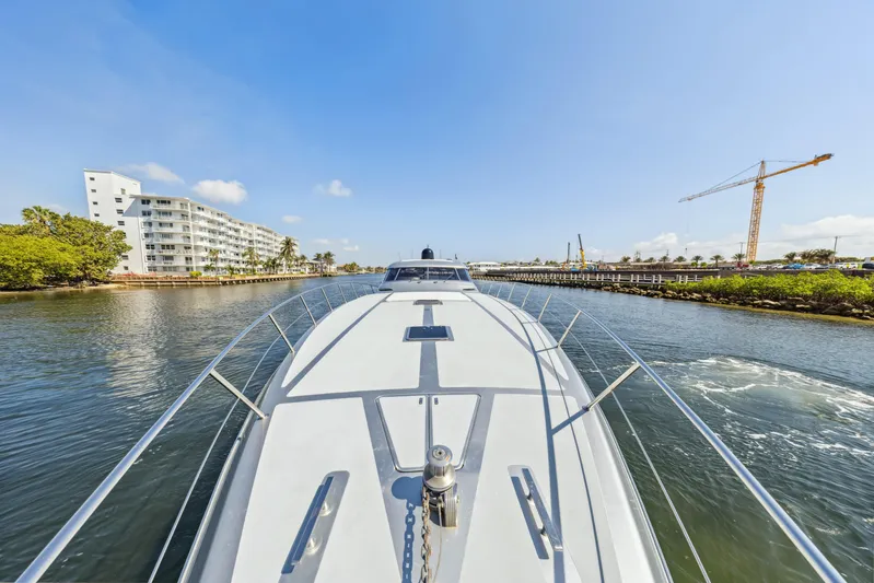 Alchemy Yacht Photos Pics 2003 Baia PANTHER 80 yacht cruising in a scenic waterway with buildings and crane.