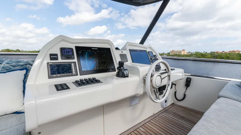 Nauti Style Yacht Photos Pics 2016 Monte Carlo Yachts MCY 65 helm with modern navigation equipment and scenic water view.