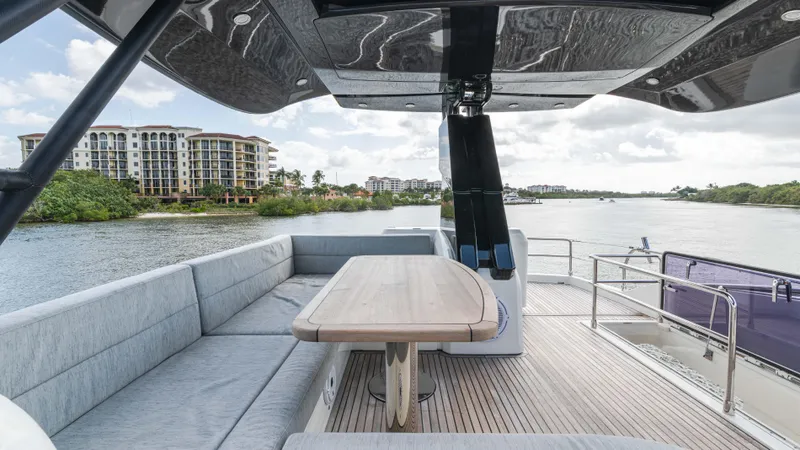 Nauti Style Yacht Photos Pics Luxurious 2016 Monte Carlo Yachts MCY 65 deck with seating, overlooking scenic waterfront.