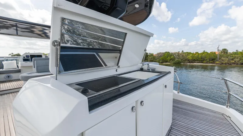 Nauti Style Yacht Photos Pics Outdoor kitchen on 2016 Monte Carlo Yachts MCY 65, featuring sleek design and scenic water view.