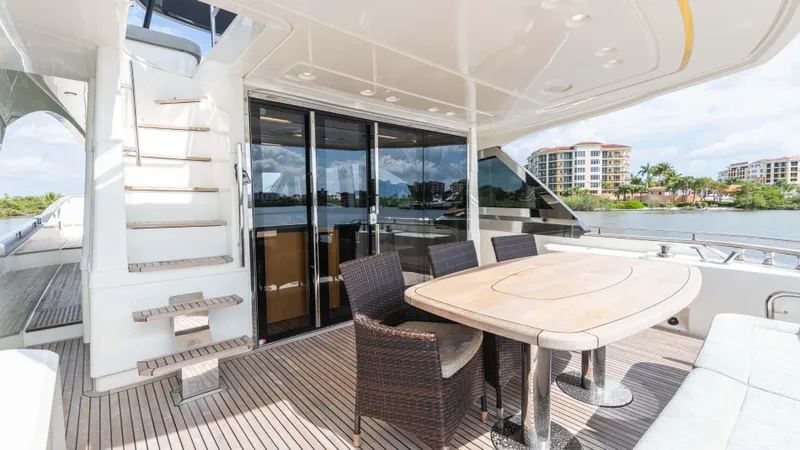 Nauti Style Yacht Photos Pics Luxurious 2016 Monte Carlo Yachts MCY 65 deck with dining area and scenic waterfront view.