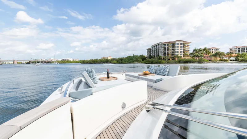 Nauti Style Yacht Photos Pics Luxurious Monte Carlo Yachts MCY 65, 2016 model, cruising near waterfront buildings.