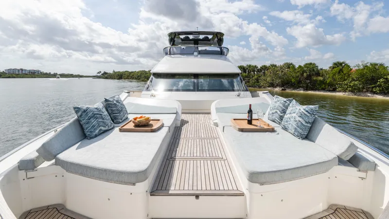 Nauti Style Yacht Photos Pics Luxurious 2016 Monte Carlo Yachts MCY 65 with elegant deck seating and scenic water view.