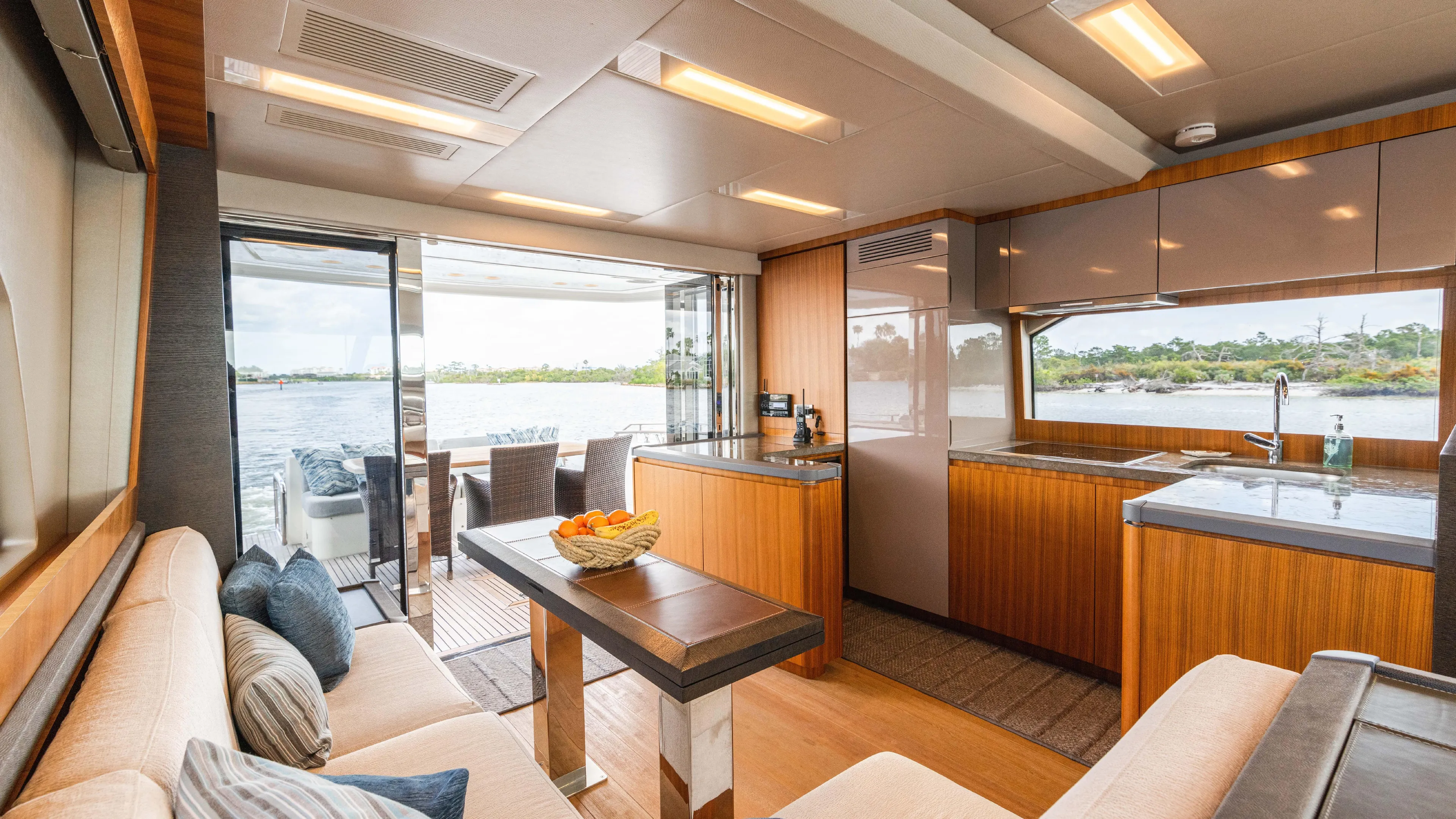 Nauti Style Yacht Photos Pics Luxurious interior of 2016 Monte Carlo Yachts MCY 65 with modern kitchen and seating area.