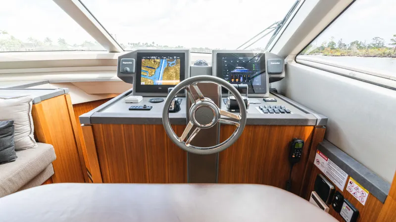 Nauti Style Yacht Photos Pics Helm of 2016 Monte Carlo Yachts MCY 65 with navigation screens and steering wheel.