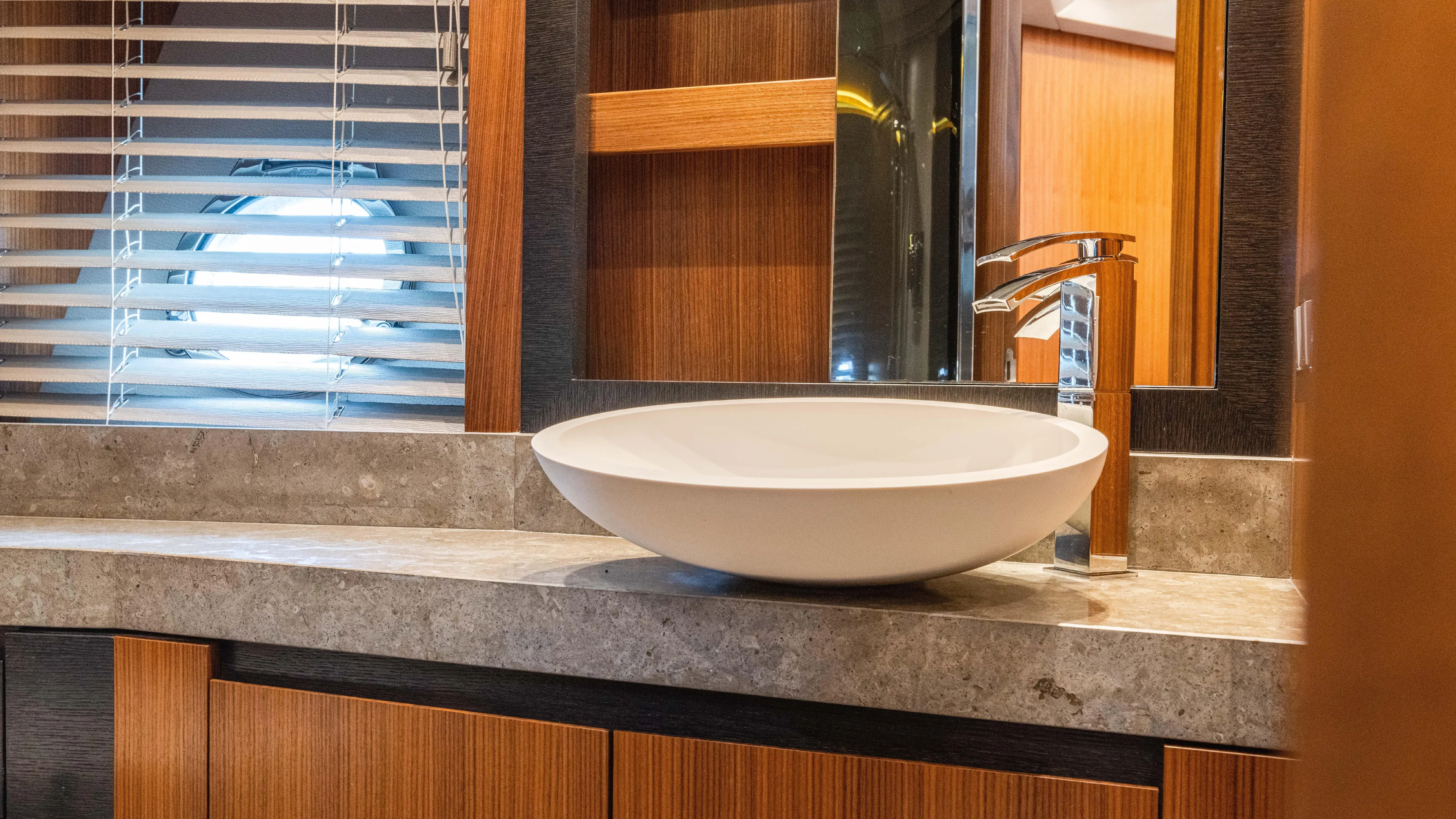 Nauti Style Yacht Photos Pics Luxurious bathroom interior of 2016 Monte Carlo Yachts MCY 65 with modern sink and porthole window.