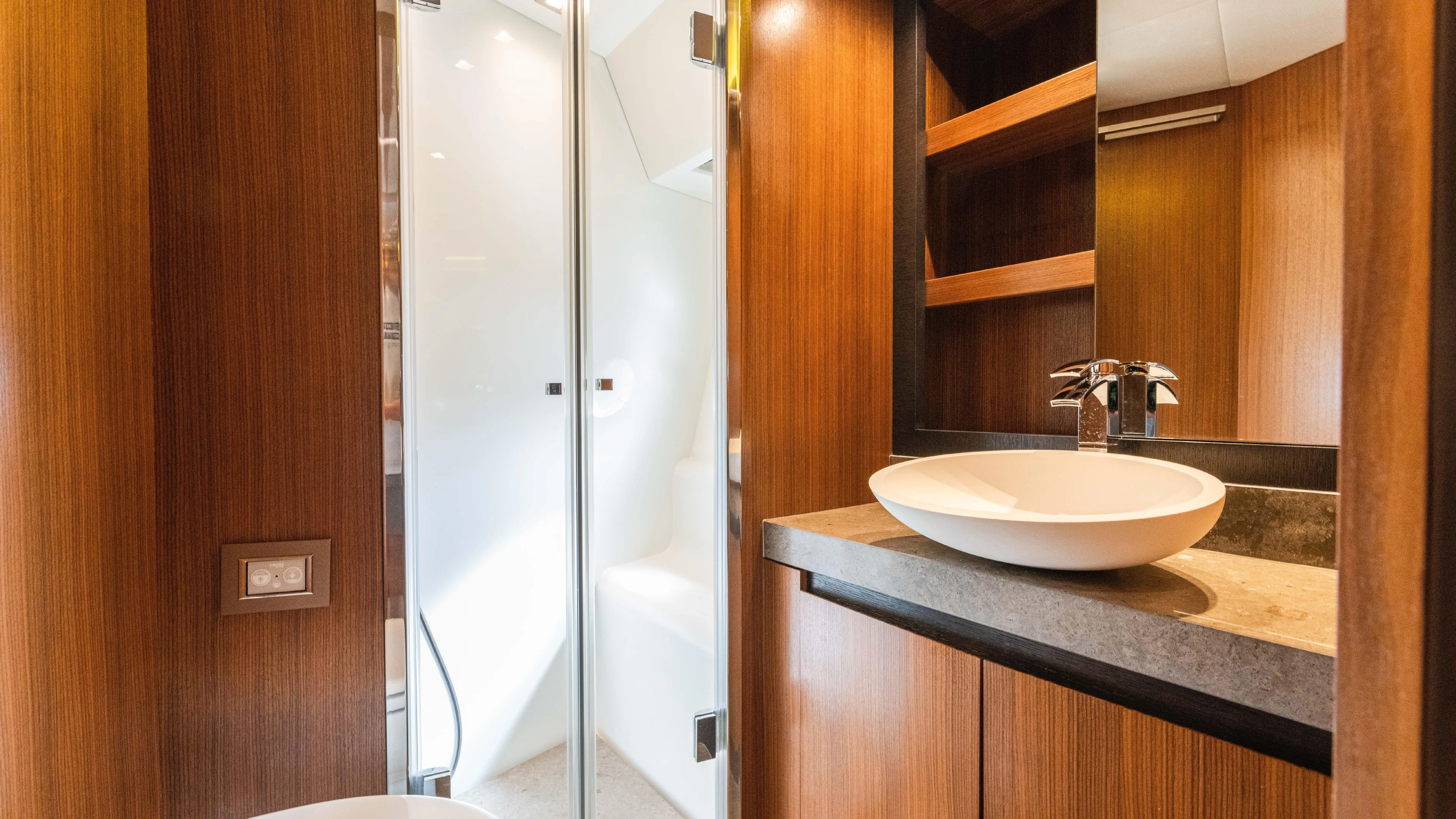 Nauti Style Yacht Photos Pics Luxurious bathroom interior of 2016 Monte Carlo Yachts MCY 65 with modern sink and wood finish.