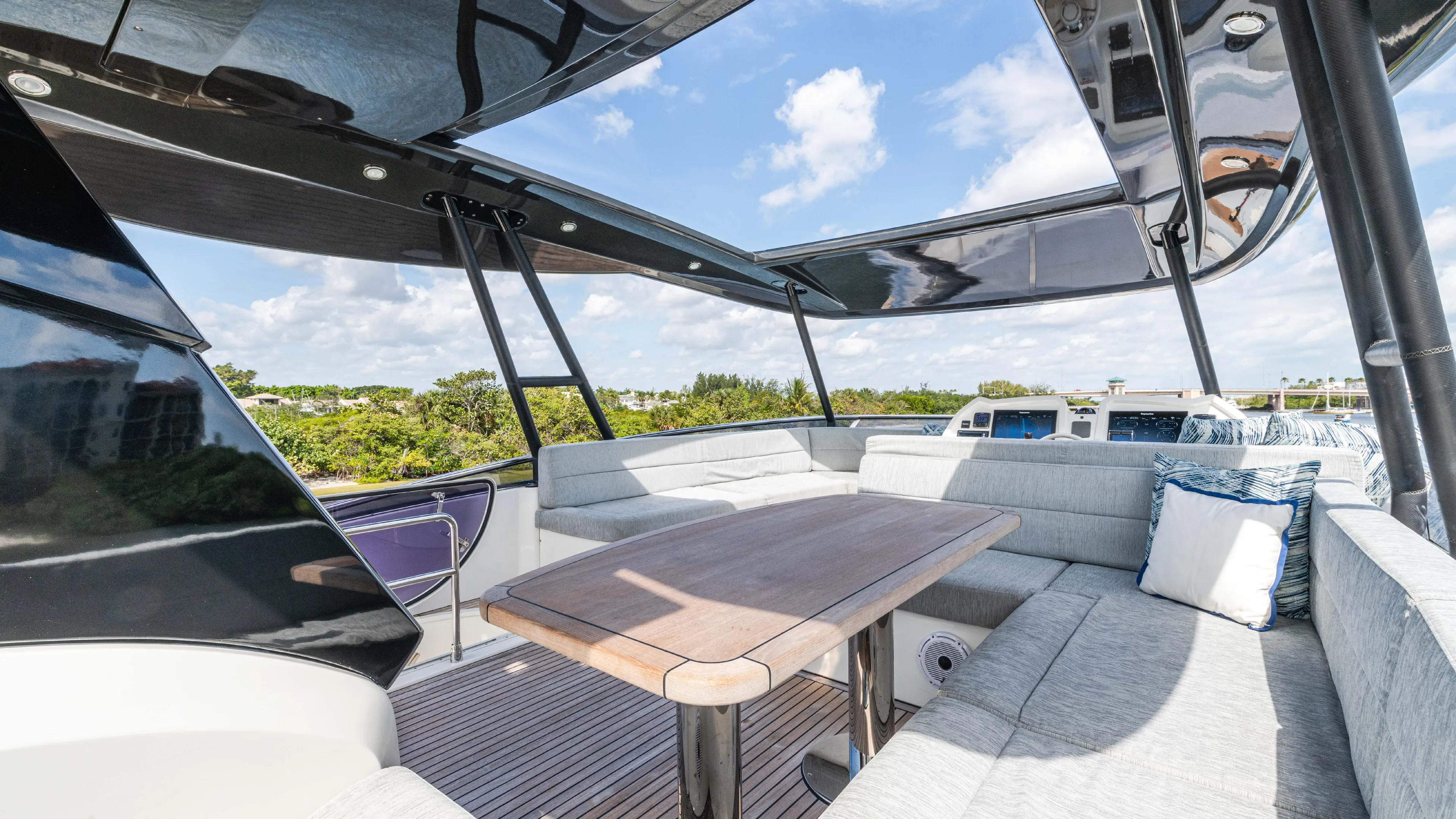 Nauti Style Yacht Photos Pics Luxurious outdoor seating on 2016 Monte Carlo Yachts MCY 65, featuring elegant cushions and wooden table.