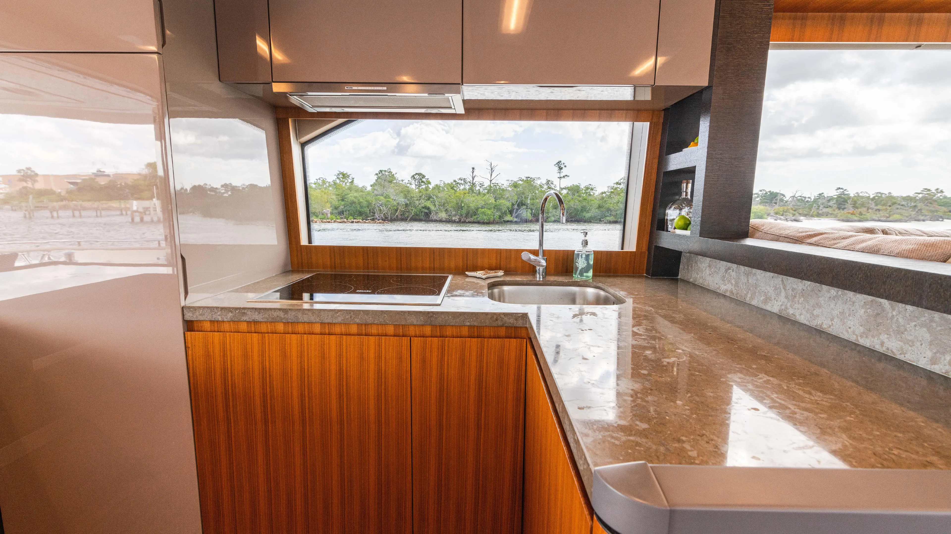 Nauti Style Yacht Photos Pics Luxurious kitchen interior of 2016 Monte Carlo Yachts MCY 65 with scenic window view.