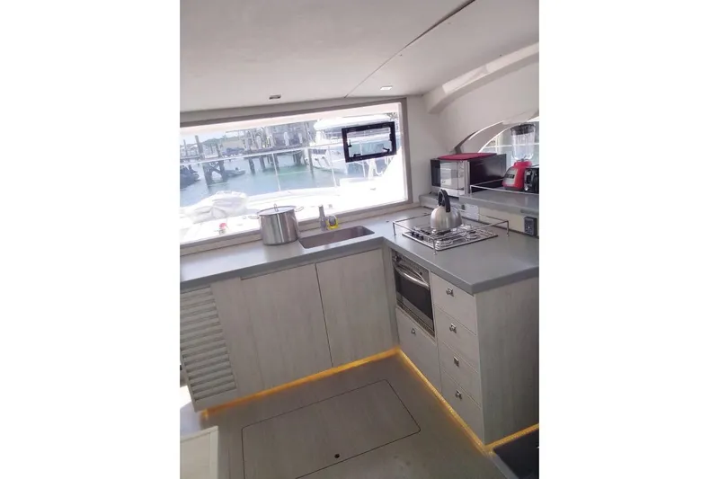 Andiamo Yacht Photos Pics Modern kitchen interior of 2020 Leopard 43 Powercat yacht with appliances and large window view.