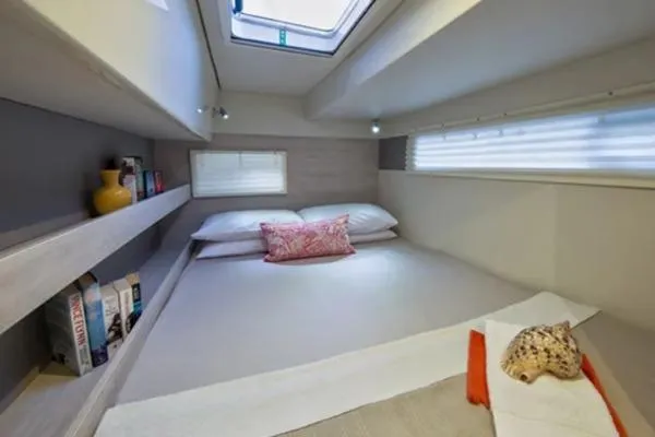 Andiamo Yacht Photos Pics Cozy cabin interior of 2020 Leopard 43 Powercat with bed, books, and decor.