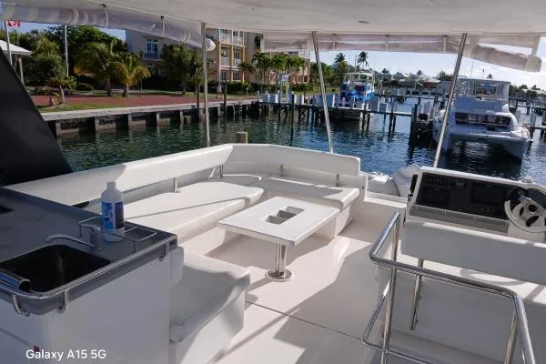 Andiamo Yacht Photos Pics Leopard 43 Powercat 2020 yacht interior with seating, table, and marina view.