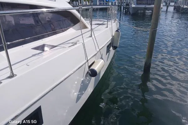 Andiamo Yacht Photos Pics 2020 Leopard 43 Powercat docked, side view with water reflections.