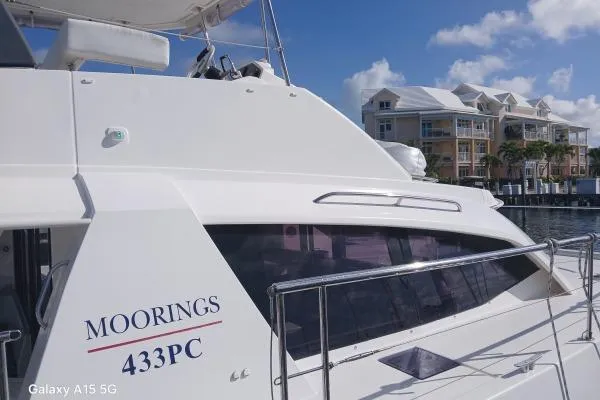 Andiamo Yacht Photos Pics Leopard 43 Powercat 2020 yacht docked near waterfront buildings under blue sky.